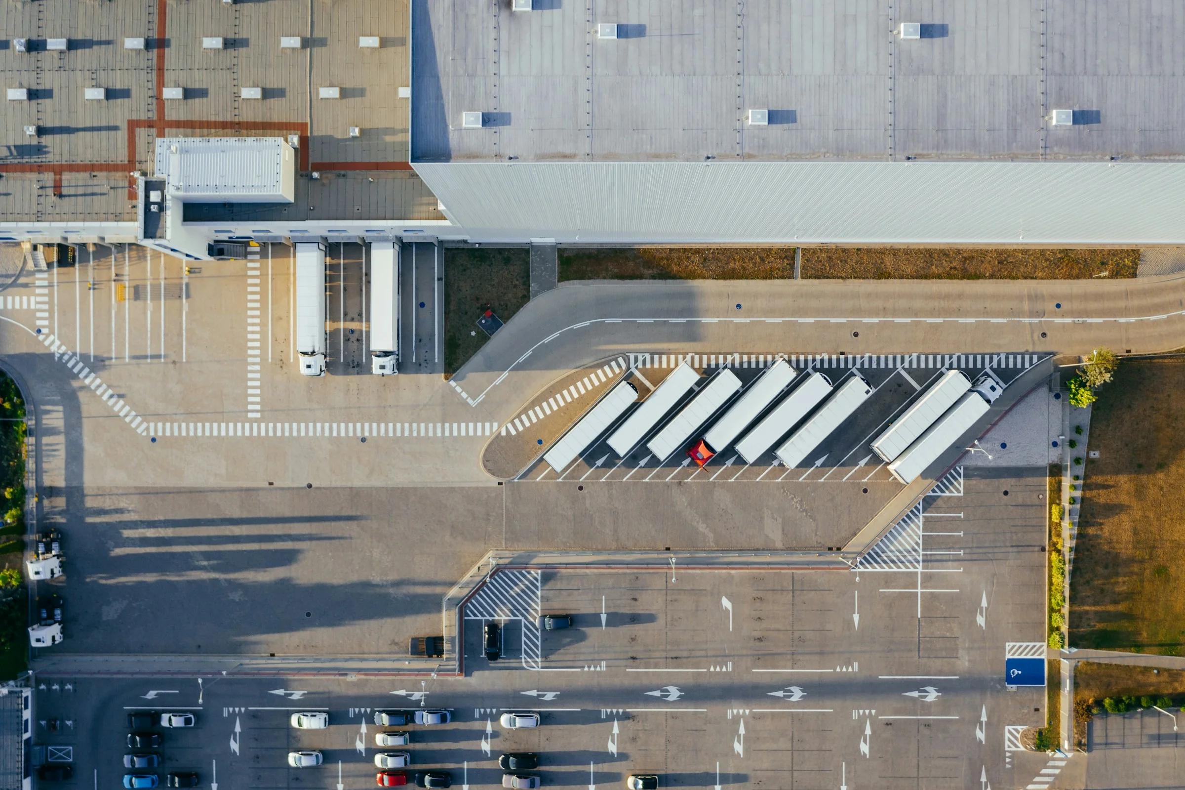 Vista aérea de centro de distribución con camiones en andenes de carga